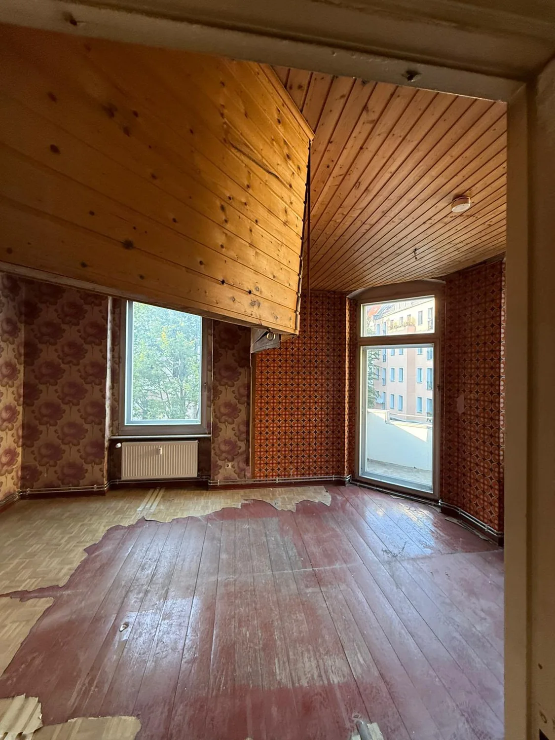 Altbau-Wohnraum vor und nach der Renovierung mit denselben beiden Fenstern und der Balkontür – Vorher