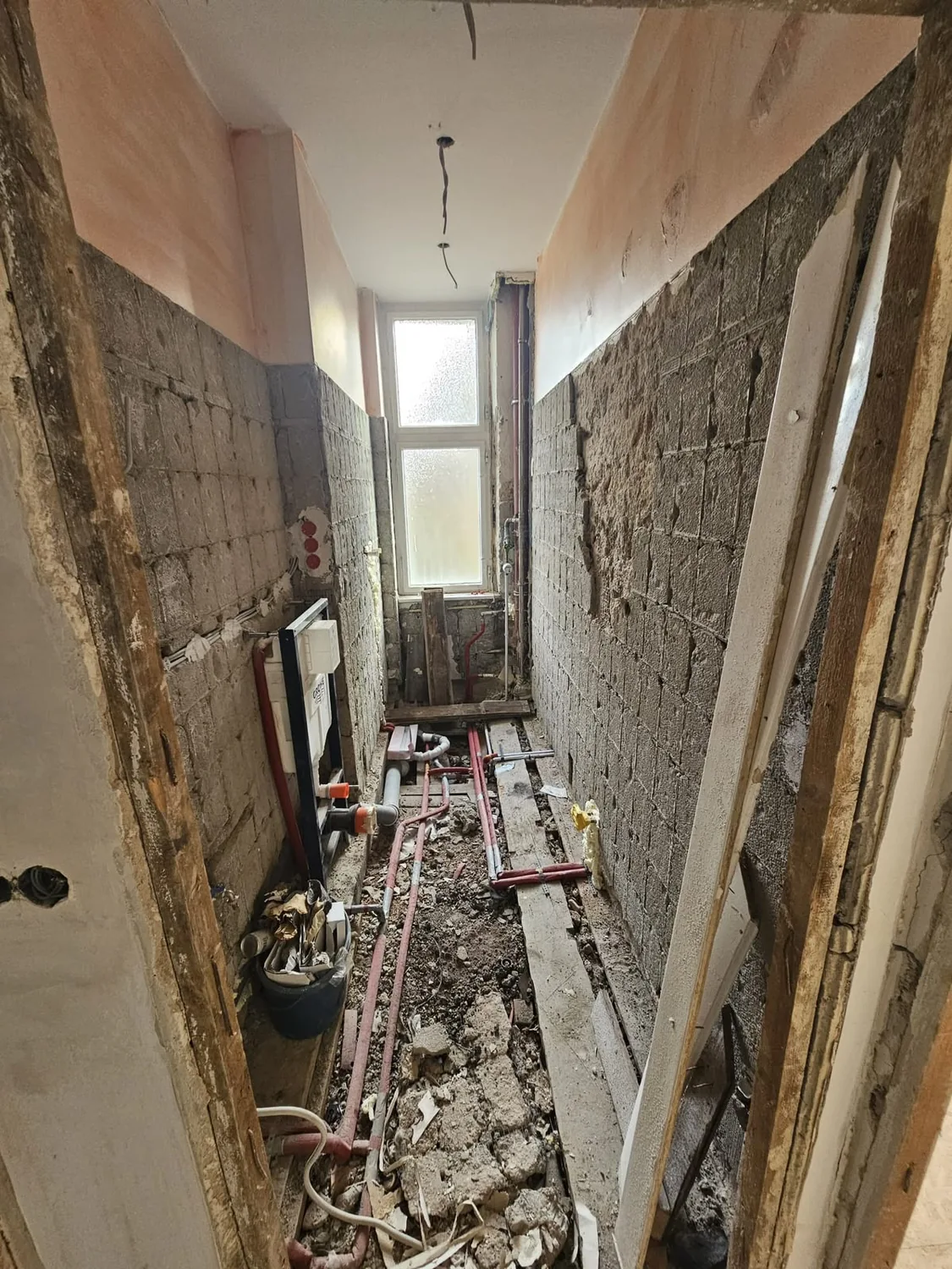 Schmales Bad mit Fenster während der Bauphase und nach der Fertigstellung – Bauphase